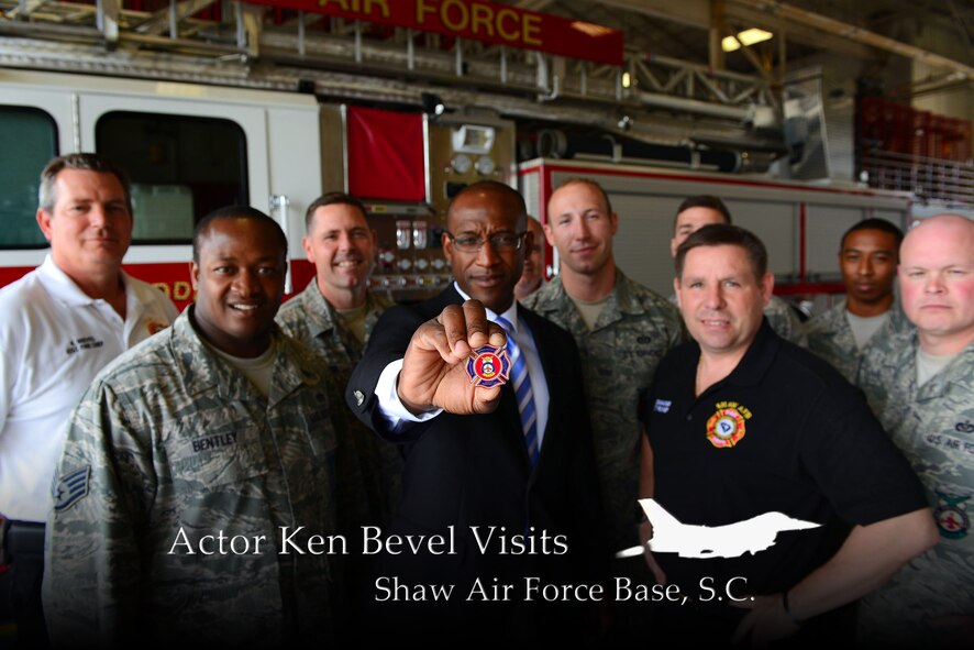 U.S. Marine Corps retired Capt. Ken Bevel presents his coin after being coined by the 20th Civil Engineer Squadron Fire Department at Shaw Air Force Base, S.C., May 1, 2014. Bevel, now a feature film actor, toured the base, visiting the 20th Security Forces Squadron, military working dog section and the fire department to thank Airmen for their service. (U.S. Air Force photo illustration by Airman 1st Class Jensen Stidham/Released)