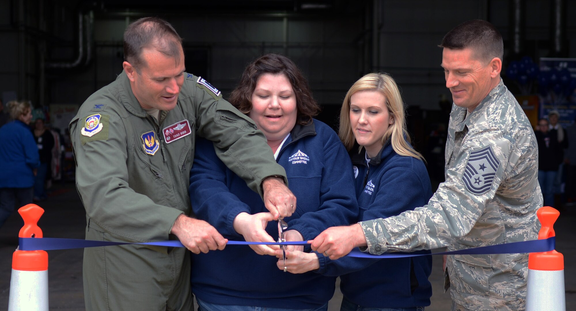 From left, U.S. Air Force Col. Kenneth T. Bibb Jr., 100th Air Refueling Wing commander, Erin Hudak, Mildenhall Enlisted and Spouses Club co-chair from Omak, Washington, Lindsey Ritenour, Mildenhall Officer and Civilian Spouses Club co-chair from Spokane, Washington, and U.S. Air Force Chief Master Sgt. Tracy Jones, 100th ARW command chief, cut the ceremonial ribbon during the 2014 Mayfair Bazaar May 2, 2014, on RAF Mildenhall, England. The ribbon cutting marks the start of the annual event that attracts vendors from throughout the United Kingdom and Europe. The bazaar is open May 2 from 2 to 6 p.m., May 3 from 10 a.m. to 6 p.m. and May 4 from 10 a.m. to 3 p.m. (U.S. Air Force photo by Airman 1st Class Kyla Gifford/Released)