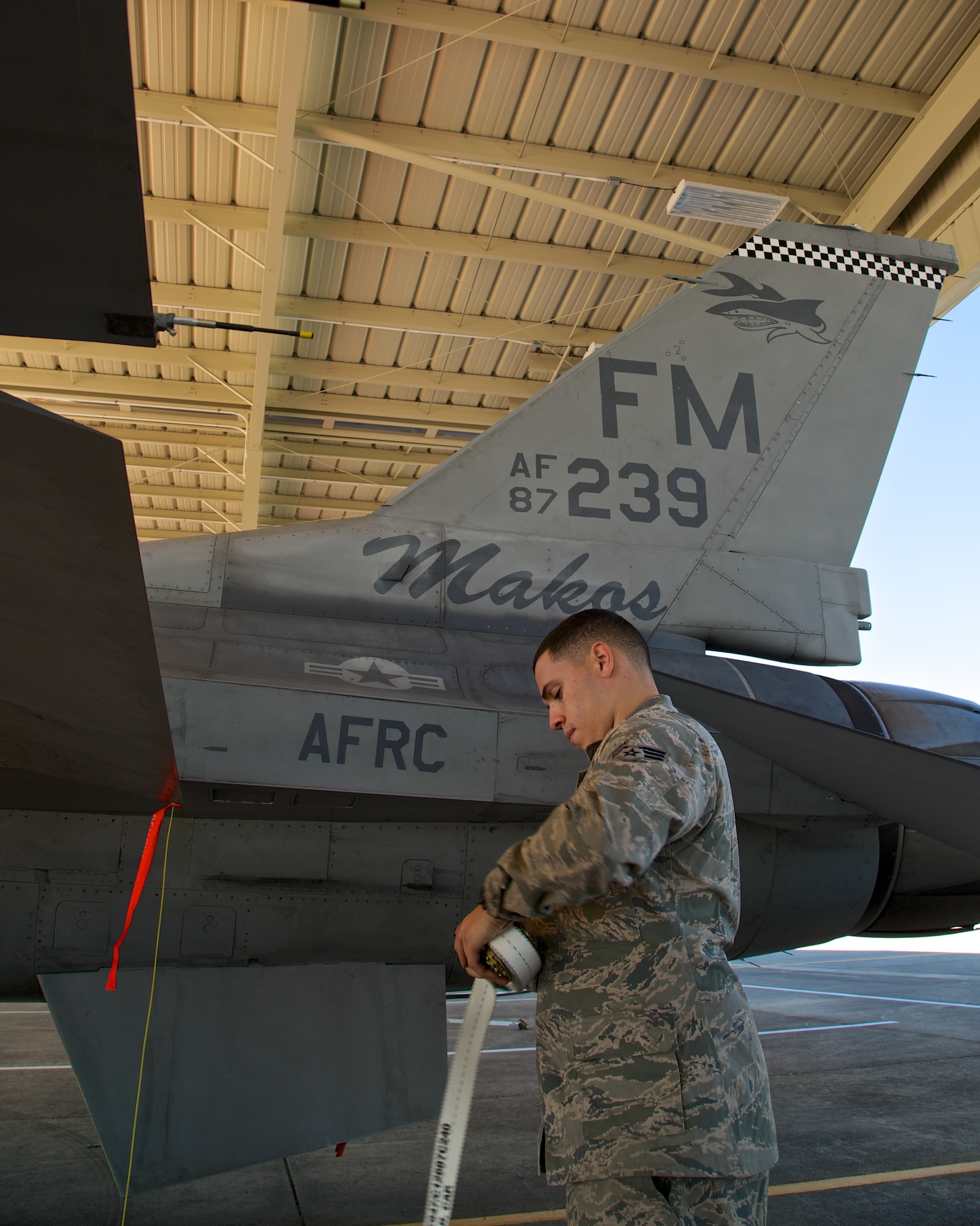 Senior Airman Jose E. Maldonado, a crew chief assigned to the 482nd Aircraft Maintenance Squadron, now stays cool and protected from the elements while working on an F-16 at Homestead Air Reserve Base, Fla. Maintainers Newly installed sunshades will help protect both Airmen and aircraft from the sometimes harsh weather conditions on the flightline. (U.S. Air Force photo/Technical Sgt. Lionel Castellano)