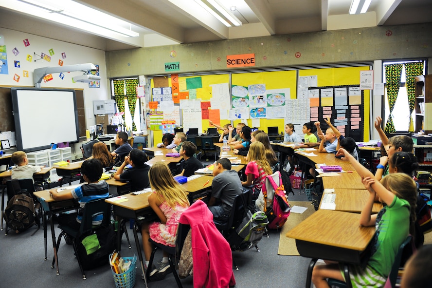 Students from the Borman Elementary School raise their hands during a Law Day visit to Borman Elementary School at Davis-Monthan Air Force Base, Ariz., May 1, 2014. The students learned that as a result of living in a democratic society, they will have the power and the opportunity to vote for who leads the country when they reach 18. (U.S. Air Force photo by Senior Airman Sivan Veazie/Released)