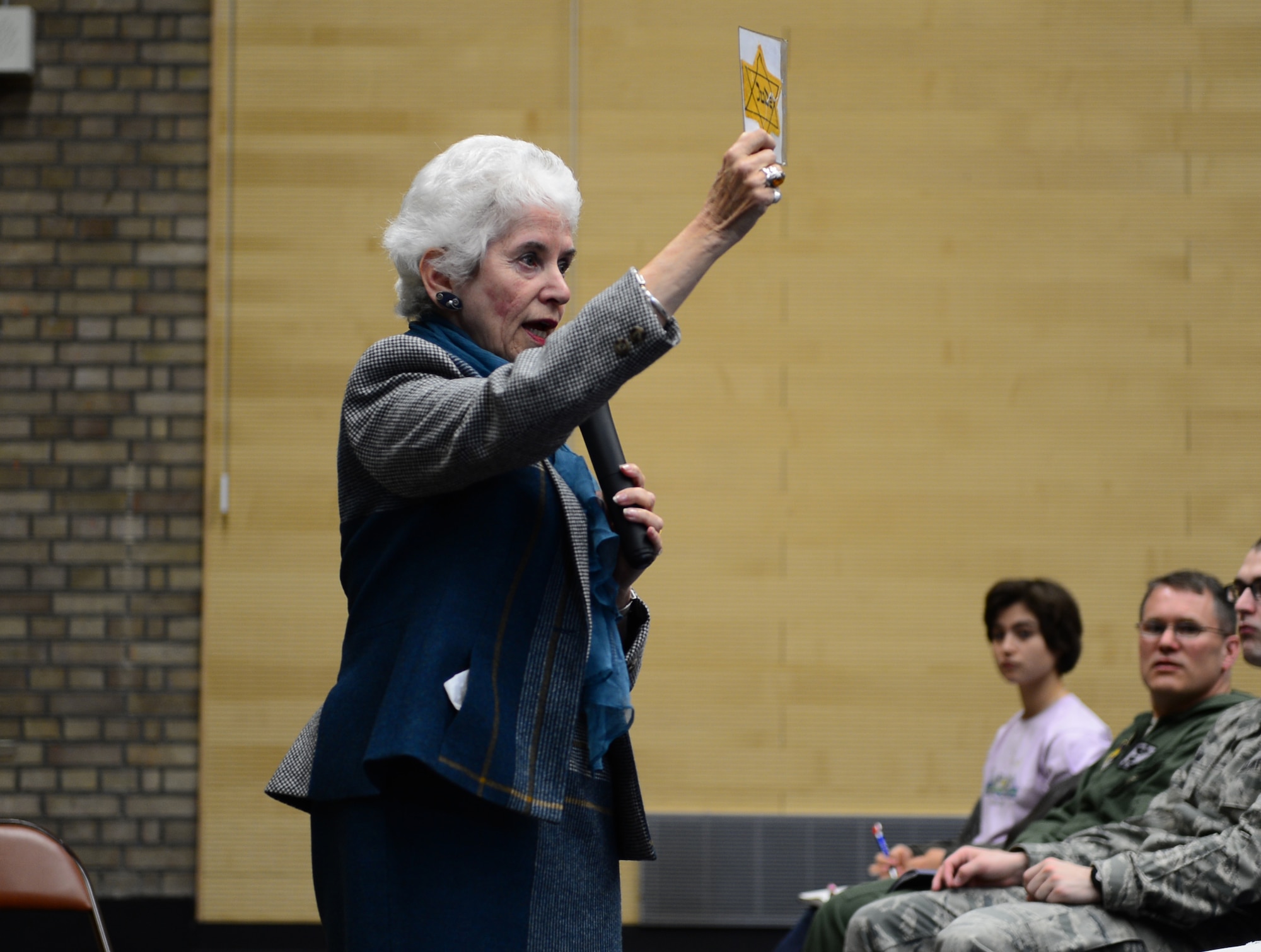Eva Clarke, who was born in a concentration camp, shows the Star of David worn her mother during World War II while speaking to students of Lakenheath High School during Holocaust Remembrance Week at Royal Air Force Lakenheath, England, April 30, 2014. Clark recounted her mother's experiences held in the concentration camp, Terezin (formerly named Theresienstadt), in the former Czech Republic during World War II. (U.S. Air Force photo by Airman 1st Class Dawn M. Weber/Released)