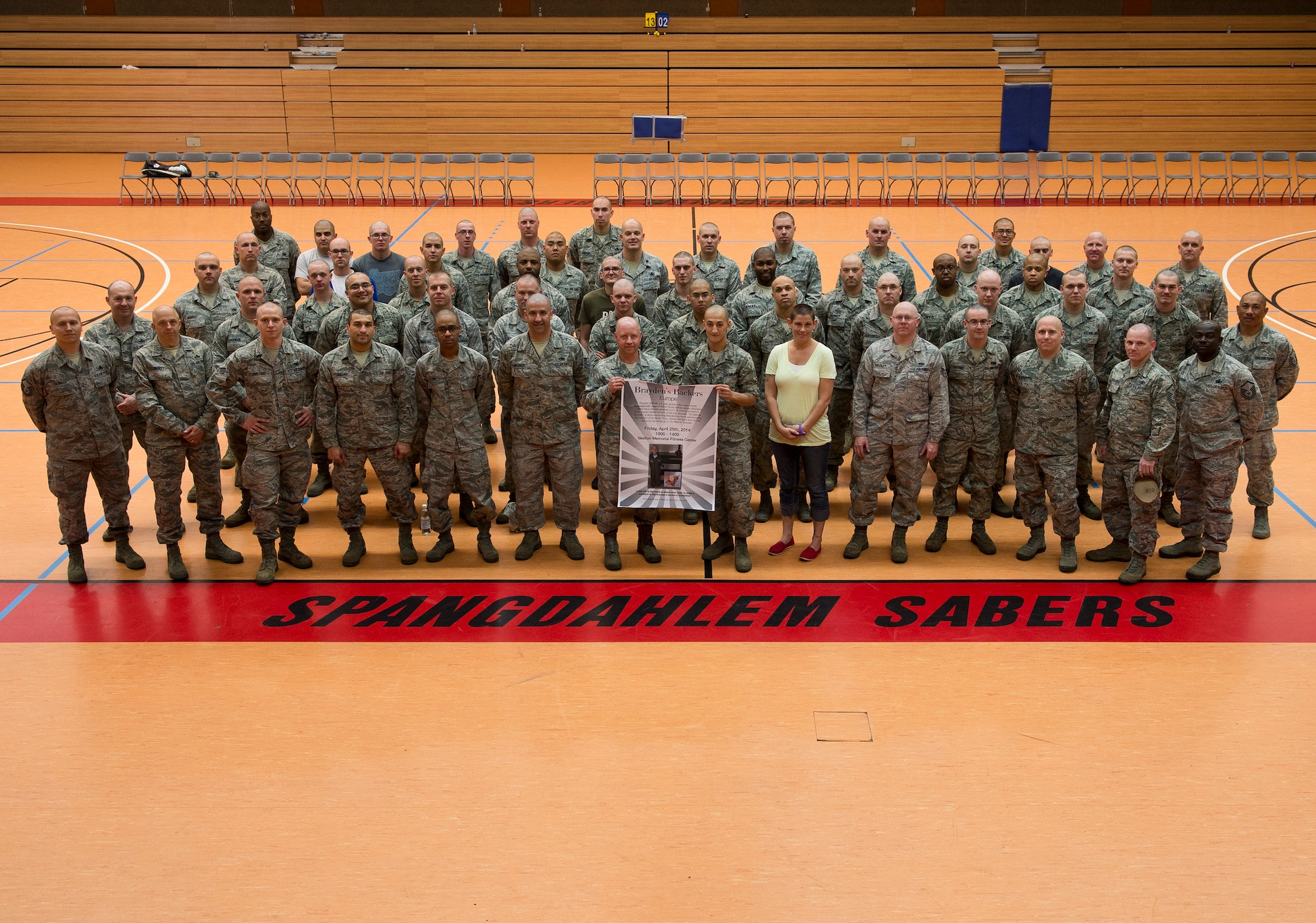 Participants in the “Go Bald for Brayden” event at Spangdahlem Air Base, Germany, pose for a group photo April 25, 2014, after shaving their heads to show support for Brayden Mitchell, 5, recently diagnosed with a form of kidney cancer. Spangdahlem Airmen donated approximately $5,000 and 120 Airmen shaved their heads. (U.S. Air Force photo by Staff Sgt. Chad Warren/Released)