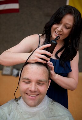 Berlynn Brownlee, a “Go Bald for Brayden” volunteer, shaves the head of U.S. Air Force Staff Sgt. David Forrest, 52nd Component Maintenance Squadron aerospace propulsion technician, April 25, 2014, at Spangdahlem Air Base, Germany, during an event to show support for Brayden Mitchell, 5, recently diagnosed with a form of kidney cancer. Brayden’s father, U.S. Air Force 2nd Lt. David Mitchell, an Ohio Air National Guard F-16 Fighting Falcon fighter aircraft pilot, died in an F-16 training accident near Luke Air Force Base, Ariz., shortly before Brayden’s birth. (U.S. Air Force photo by Staff Sgt. Chad Warren/Released)