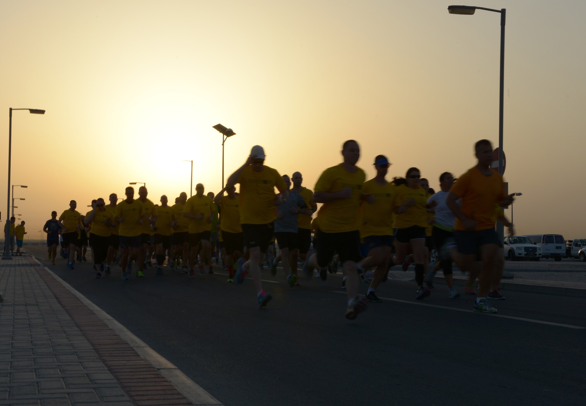Nearly 150 service members run during sunset during a Pat Tillman remembrance run at Al Udeid Air Base, Qatar, April 27, 2014, to honor the legacy of a man who gave up everything to fight for the freedoms of American citizens. April 22, 2014, marked the tenth anniversary of Tillman’s death, and the men and women who are stationed at AUAB ran to remember his sacrifices as an Army Ranger. Forty two is a number closely associated to Tillman, as it was his jersey number when he played football for Arizona State University as a linebacker, which is why the participants ran a total of 4.2 miles. (U.S. Air Force photo/Senior Airman Hannah Landeros) 