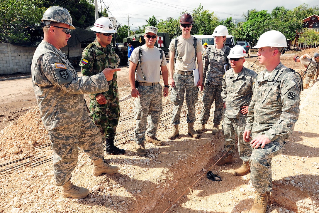 U.S. Army Sgt. Maj. Darrel Sears, left, talks to service members about