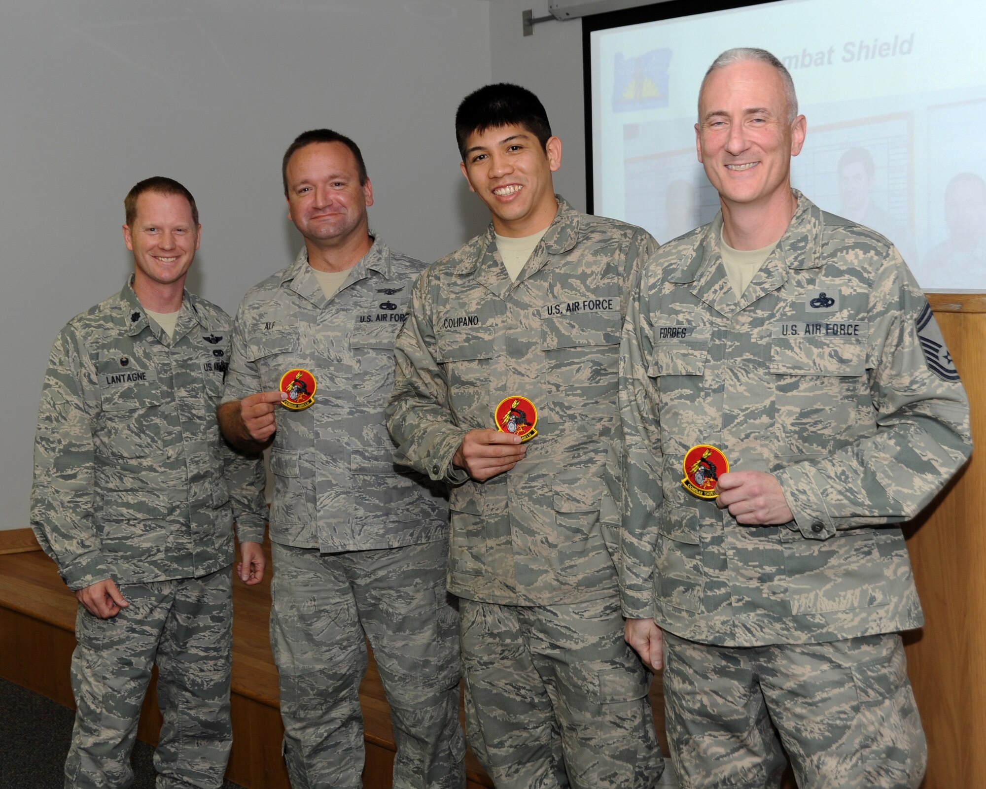 During the unit’s Commander’s Call, May 3, 2014, Lt. Col. Chris Lantagne, 142nd Aircraft Maintenance Squadron Commander, left, presents Tech. Sgt. Trevor Alf, Staff Sgt. Bryson Colipano and Senior Master Sgt. Darren Forbes with Combat Shield patches in recognition of their outstanding performance during the Combat Shield evaluation held at the Portland Air National Guard Base, Ore. April 17-18. (Air National Guard photo by Master Sgt. Shelly Davison, 142nd Fighter Wing Public Affairs/Released)