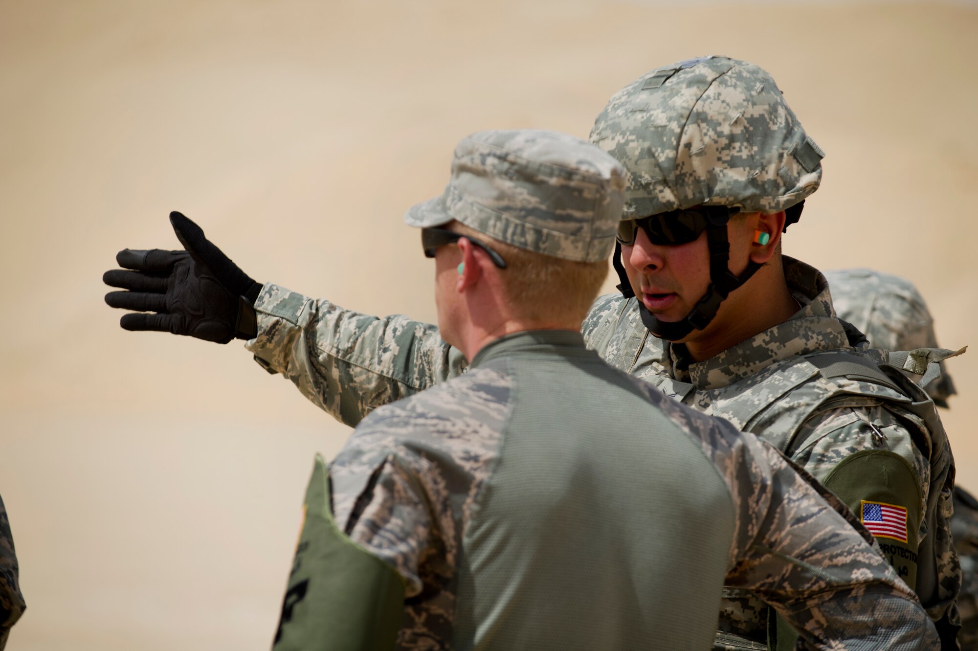 Senior Airman Julio Morales, deployed from Joint Base San Antonio, discusses proper firing technique with his combat arms instructor, Senior Airman Phillip Williams.  Morales, a member of the 387th Support Squadron Force Protection team, received weapons proficiency training with combat arms instructors from the 387th Expeditionary Security Forces Squadron while deployed to the AOR.  Because Force Protection Airmen act as augmentees to security forces, it is important that they receive on-going proficiency training to ensure they are ready to properly react and respond during times of increased threats.  (U.S. Air Force photo by Senior Master Sgt. Burke Baker)