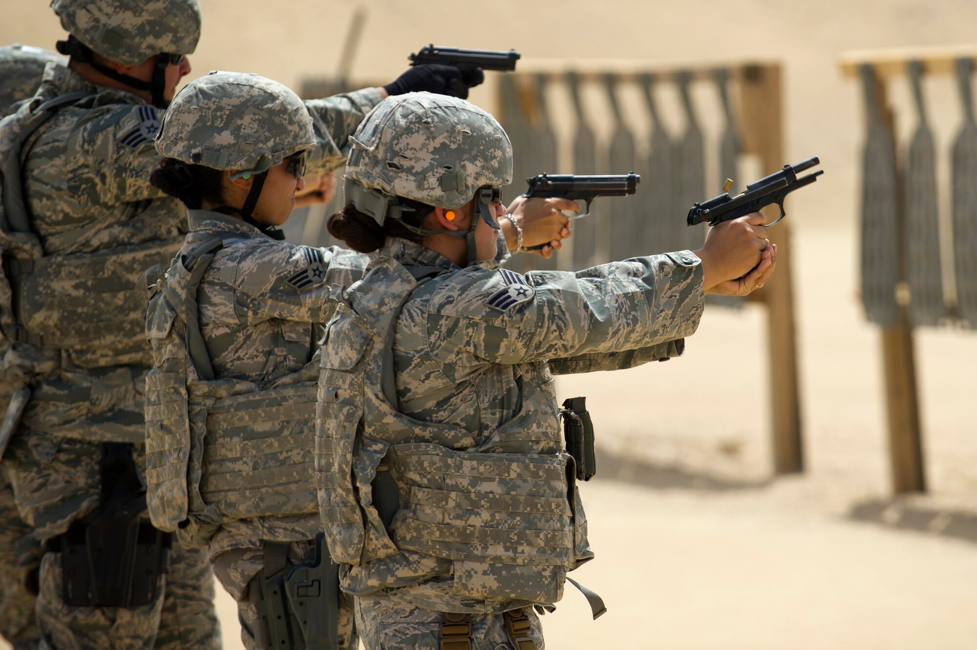Senior Airman Christina White, a Force Protection Airman with the 387th Expeditionary Support Squadron, engages a target with her M-9 pistol.  White, a native of Bushkill, Pa., received weapons proficiency training with combat arms instructors from the 387th Expeditionary Security Forces Squadron while deployed to the AOR.  Because Force Protection Airmen act as augmentees to security forces, it is important that they receive on-going proficiency training to ensure they are ready to properly react and respond during times of increased threats.  (U.S. Air Force photo by Senior Master Sgt. Burke Baker)