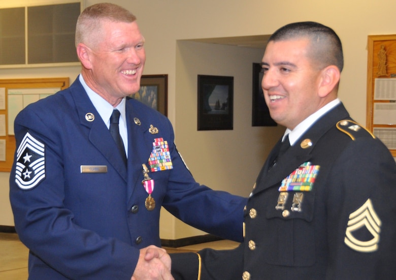 Chief Master Sergeant Shane Clark is congratulated by Sgt. First Class Francisco Ledesma after assuming responsibility as the Arizona National Guard Senior Enlisted Advisor. (U.S. Air National Guard photo by Capt. Matt Murphy/Released)