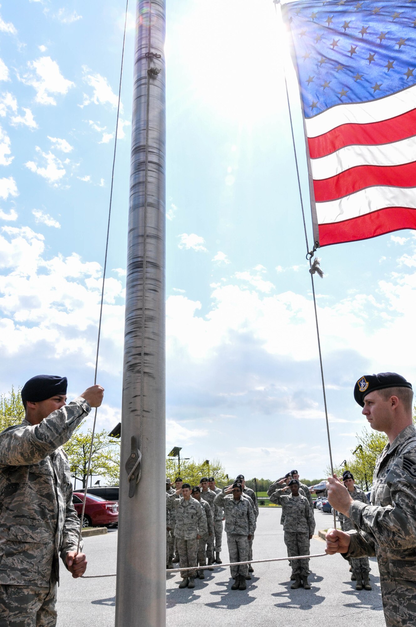 Airmen of the 166th Security Forces Squadron, Delaware Air National Guard, render salutes as the flag is lowered during a 166th Airlift Wing retreat ceremony May 3, 2014, at the New Castle ANG Base in New Castle, Del. Retreat serves a twofold purpose. It signals the end of the official duty day and serves as a ceremony for paying respect to the flag. (U.S. Air National Guard photo by Tech. Sgt. Robin Meredith)