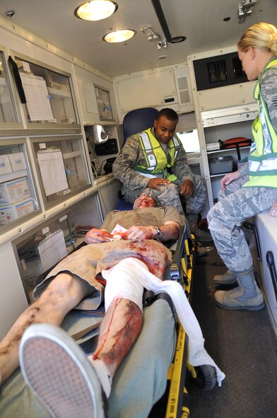 403rd Aeromedical Staging Squadron medical technicians, Senior Airmen Philip Newsome and Kandice Waddell, check on the simulated patient Staff Sgt. Jonathan West, network infrastruction technician from Warrior Preparation Center, Einseidlerhof, Germany, while being transported by ambulance during a mass casualty exercise here May 3, 2014.  West had a simulated compound fracture of the left thigh and a simulated cut to the forehead for the purpose of this exercise.  Patient transport by ambulance was evaluated during the mass casualty exercise to ensure the ASTS operational readiness. (U.S. Air Force Photo/Master Sergeant Jessica L. Kendziorek)
