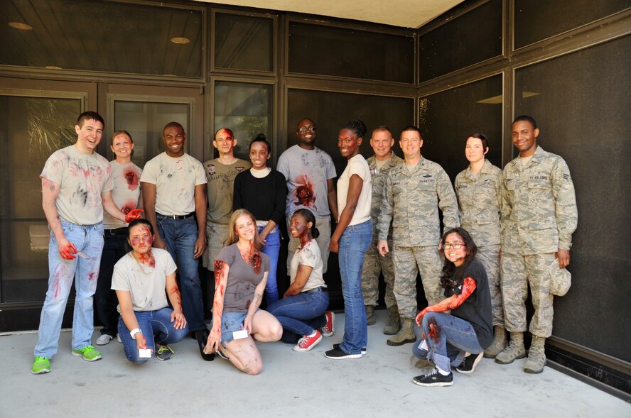 Col. Frank Amodeo, 403rd Wing Commander (third from right, standing), and Chief Master Sergeant Christopher L. Barnby, 403rd Wing Command Chief Master Sergeant (fourth from right, standing), pose next to volunteer airmen with simulated injuries before a mass casualty exercise here May 3, 2014.  The mass casualty exercise was organized by the 403rd Aeromedical Staging Squadron to test medical personnel for operational readiness. (U.S. Air Force photo/Master Sergeant Jessica L. Kendziorek)