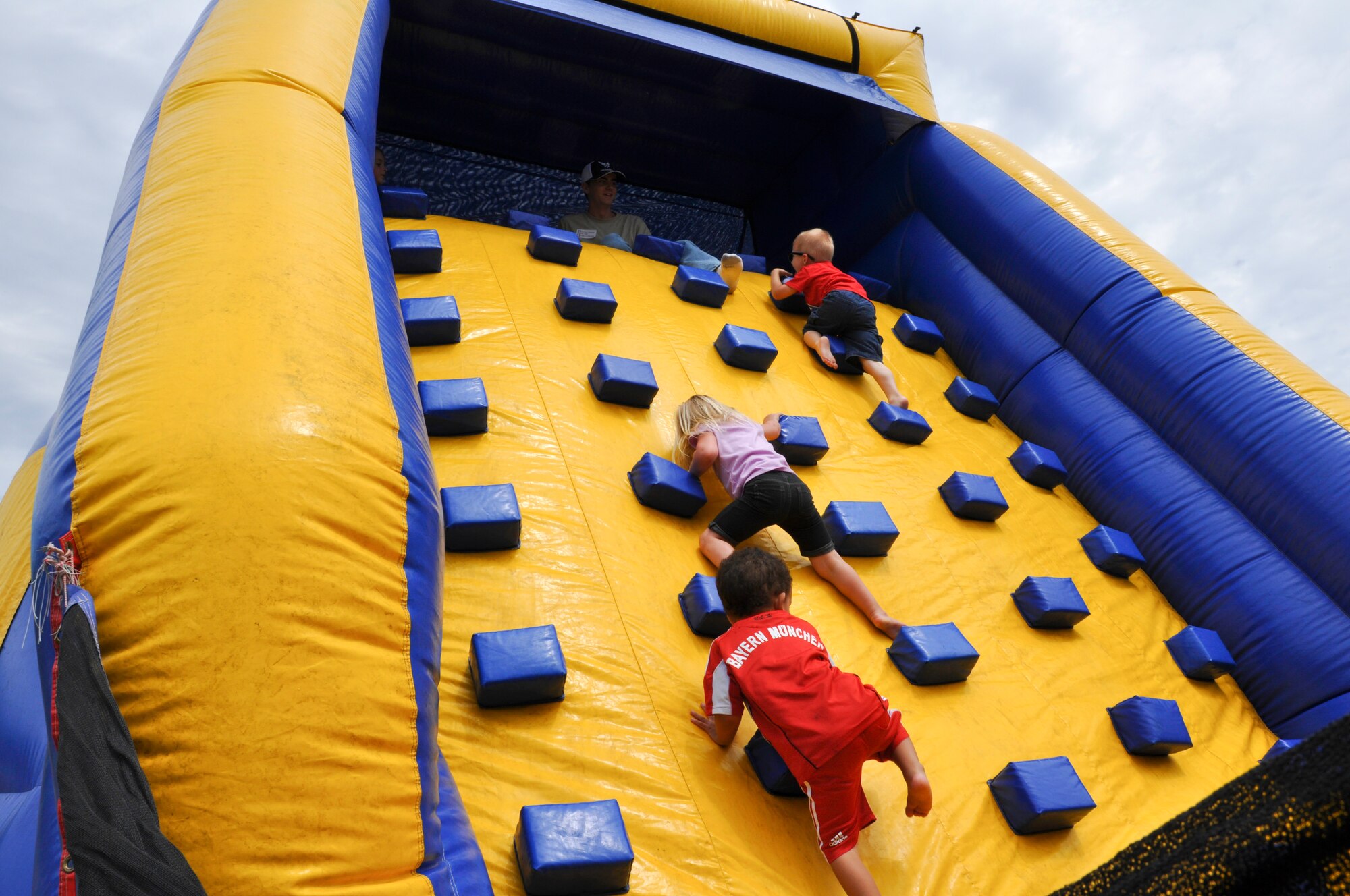 Children climb to the top of the inflatable slide during the annual Joint Base Charleston Appreciation Picnic May 3, 2014 at the Air Base picnic grounds. The two-day event, which was open to all of Team Charleston, had a wide-range of activities available to both adults and children, including a jousting station, inflatable water slide, corn hole tournament, and a mini C-17 static display. More than 2,000 people attended the picnic this year. (U.S. Air Force photo/Capt. Michaela Judge)