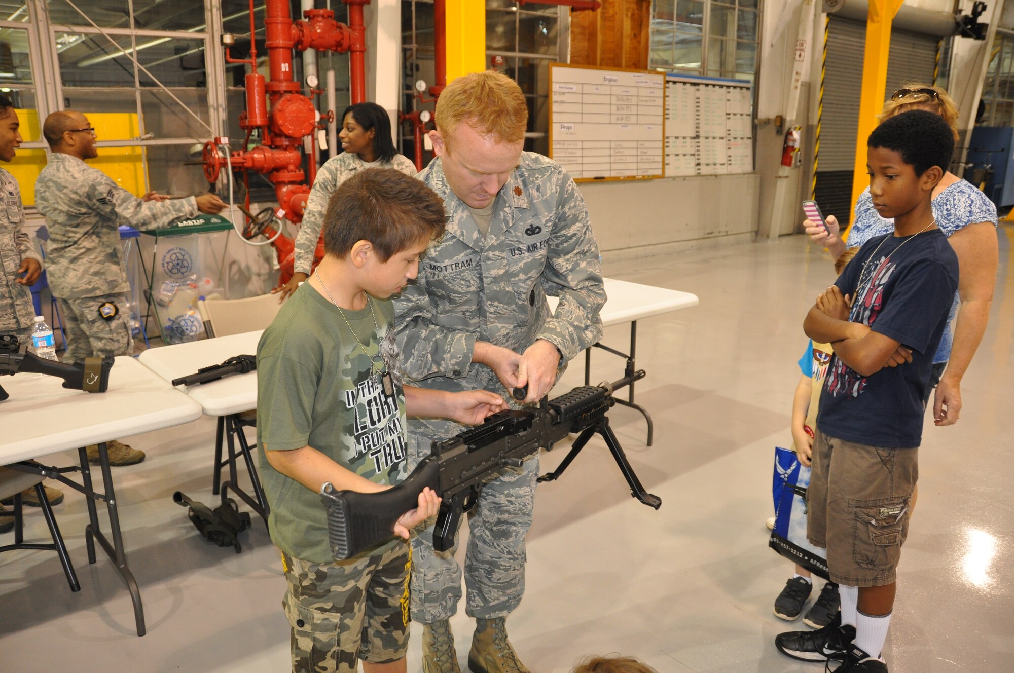 POPE FIELD, N.C. - Nicholas Sevarino is taught the finer points of the M240 by Maj. Charles Mottram of the 440th Security Forces Squadron while his foster brother Christopher Singletary looks on at the 2014 Passport to Adventure held here, May 3.  