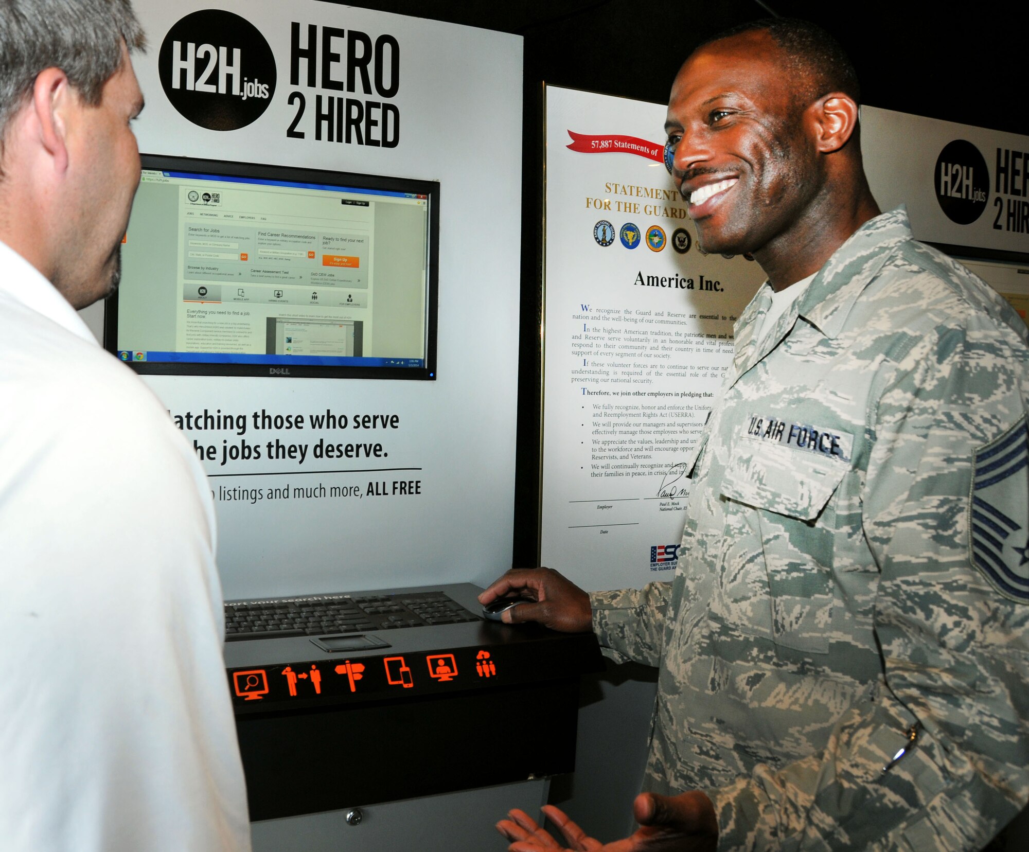 Chief Master Sgt. Reginald Edwards from Family and Employer Programs and Policy Headquarters, Washington, D.C., gives instruction on how to use the Hero 2 Hired mobile job store kiosk as part of a two-day employment event sponsored by the 512th Airlift Wing Airman & Family Readiness office May 3, 2014 on Dover Air Force Base, Del. The H2H system boasts a high-tech system that allows users to view nearly  3,700,000 jobs with more than 25,000 employees.