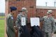 Lt. Col. Gonzalo Reyna, 906th Air Refueling Squadron Commander, and Senior Master Sgt. Justin Wright, the maintenance supervisor for the 906 Air Refueling Squadron, unveil the new artist rendition of the plaques for Capt. Brandon Cyr, a pilot for the 906 ARS, that will be added to the memorial wall during a memorial service at Scott Air Force Base Ill., April 24, 2014. Cyr died in a plane crash on April 27, 2013, while deployed to Afghanistan. The memorial service was presented by U.S. Air Force airmen of the 906 ARS and Illinois Air National Guard members assigned to the 126th Air Refueling Wing. (Air National Guard photo by Senior Airman Elise Stout)