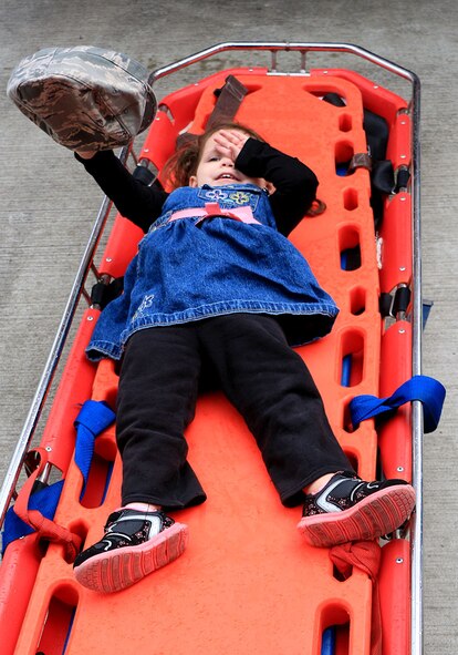 Georgia Madrid, daughter of Tech. Sgt. Andrew Madrid who is an avionics mechanic with the 446th Aircraft Maintenance Squadron, lies on a stretcher at a Joint Base Lewis-McChord fire department May 3. Tiger Scout and Boy Scout troops learn about different tasks that are carried out by Airmen during a base tour at McChord Field, Washington. (U.S. Air Force Reserve photo by Senior Airman Madelyn McCullough)