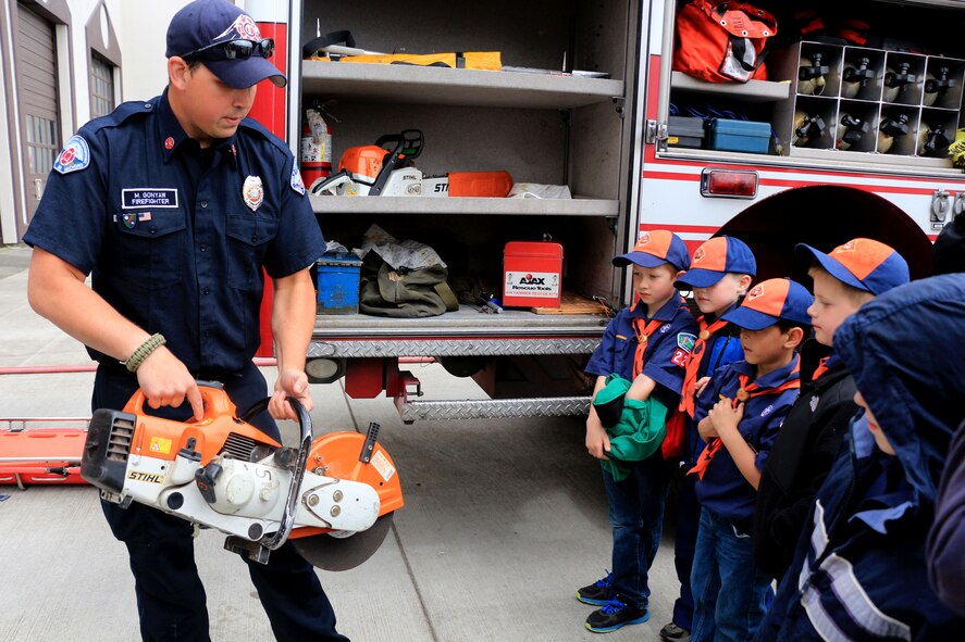 Tiger Scouts from Troop 222 of the Key Peninsula Area in Washington, watch as Mike Gonyaw, firefighter with Joint Base Lewis-McChord fire department, explains one of the tools used in emergency situations during a base tour May 3. The scouts learned about nearly all the equipment firefighters use when responding to emergencies such as aircraft accidents. (U.S. Air Force Reserve photo by Senior Airman Madelyn McCullough)