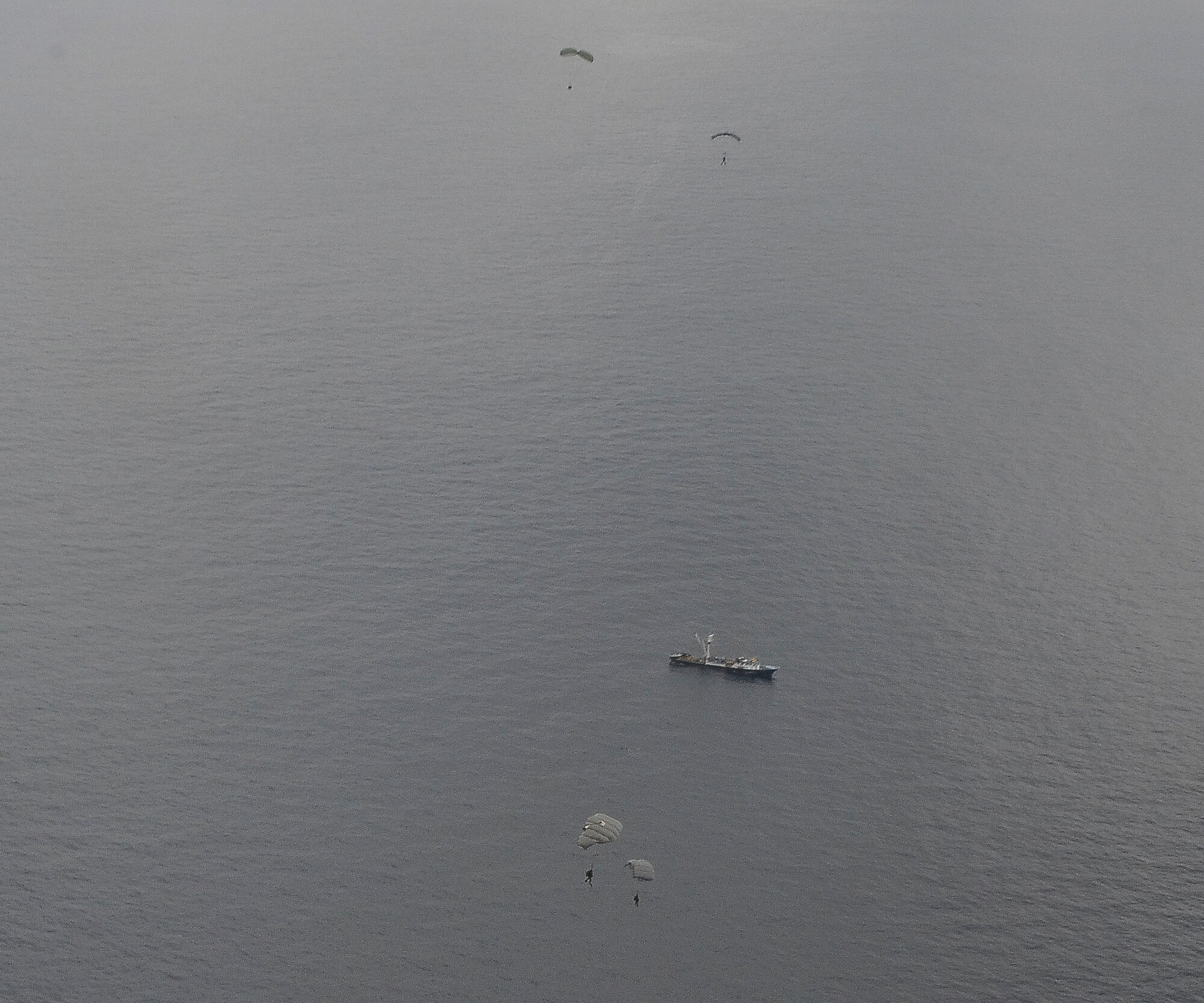 U.S. Air Force pararescue Airmen from the 48th Rescue Squadron parachute into the Pacific Ocean to aid to two critically injured sailors aboard a Venezuelan fishing boat May 3, 2014. The Airmen flew in two HC-130J Combat King II aircraft and three HH-60 Pavehawk helicopters for nearly 11 hours, and then parachuted into the ocean 1,100 nautical miles off the Mexican coast with two inflatable zodiac boats and medical equipment to deliver lifesaving care. (U.S. Air Force photo by Staff Sgt. Adam Grant/Released) 