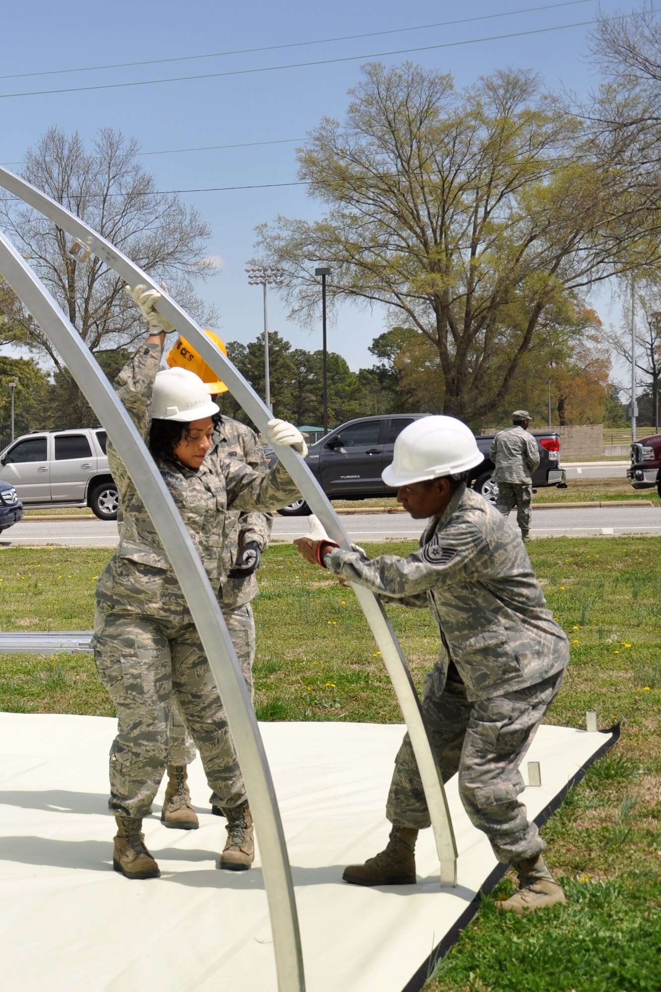 Members of the 916th Force Support Squadron and 567th Red Horse Squadron work together during shelter setup training in Debden Park, April 2014. FSS Airmen benefited from the expertise of Red Horse members while training on shelter setup, a responsibility shared by both units.