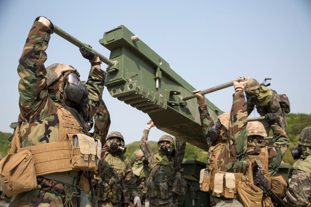 Republic of Korea and U.S. Marines lift a component of a medium girder bridge April 25 during Korean Marine Exchange Program 14-6 in Pohang, Republic of Korea. The exercise highlights the ROK and U.S. combined commitment to the defense and security of the Asia-Pacific region. The ROK Marines are with 1st ROK Marine Engineer Battalion, 1st ROK Marine Division. The U.S. Marines are with 9th Engineer Support Battalion, 3rd Marine Logistics Group, III Marine Expeditionary Force. 