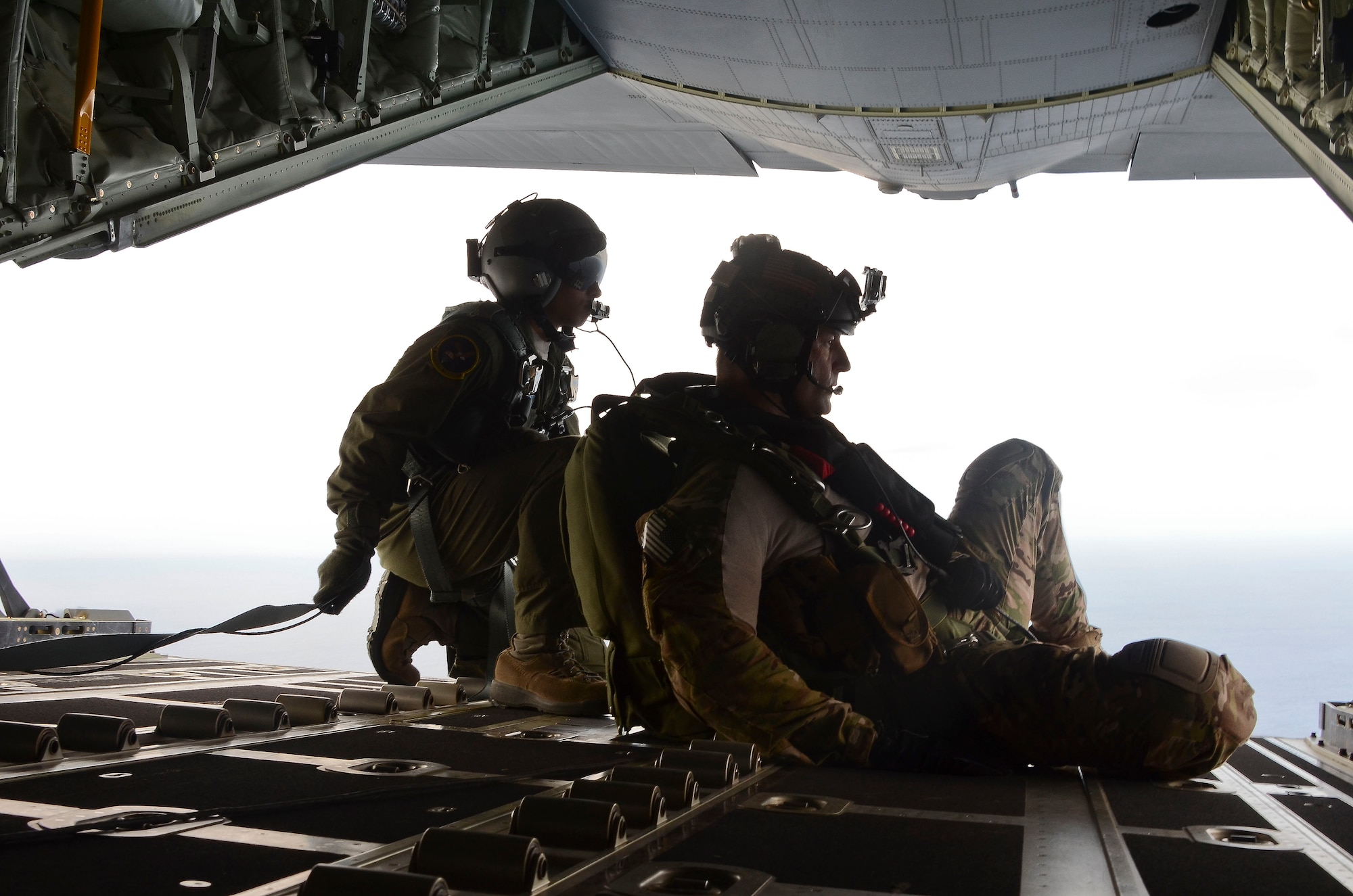 Pararescue Airmen survey the area before parachuting into the Pacific Ocean May 3, 2014, to aid to two critically injured sailors aboard a Venzuelan fishing boat. The pararescue Airmen flew in two HC-130J Combat King II aircraft and three HH-60 Pavehawk helicopters for nearly 11 hours, and then parachuted into the ocean along with two inflatable zodiac boats and medical equipment to deliver lifesaving care. The pararescue Airmen involved in the operation are from the 48th Rescue Squadron. (U.S. Air Force photo/Staff Sgt. Adam Grant) 