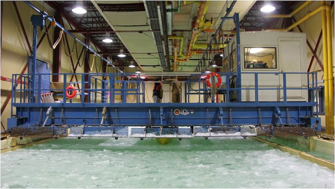 A view of the Ice Engineering Facility’s Test Basin, including the main overhead carriage assembly (blue) for instrumentation, controls, general monitoring, towing of scaled physical models, and other activities.