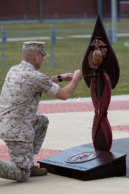Master Chief Jody Fletcher, command master chief for U.S. Marine Corps Forces Special Operations Command, takes a knee and gently hangs the dog tags of one of his fallen comrades on the MARSOC Honor the Fallen memorial, during ‘Honor the Fallen,’ a one-of-a-kind event, April 25, at the MARSOC headquarters, to honor all Marines, sailors and civilian Marines lost at home and abroad since MARSOC’s inception. “Honor the Fallen is about honoring and reflecting upon the memory and life of all of our fallen MARSOC Marines and sailors to include all civilians who have served with MARSOC in any capacity, and the remarkable contributions they made in serving our great nation, protecting our freedom and liberties,” said Kristin Smith, the Family Readiness Officer for MARSOC headquarters.  “We are remembering and honoring all of our fallen with the respect they so much deserve.”