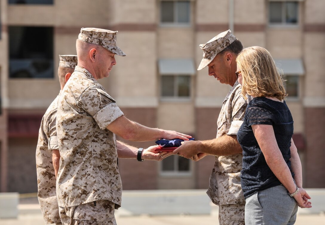 Lieutenant Col. John R. O'Neal, left commanding officer, 15th Marine Expeditionary Unit, presents an American flag, along with the Meritorious Service Medal, to Lt. Col. William D. Wischmeyer, executive officer, 15th MEU, during his retirement ceremony aboard Camp Pendleton, Calif., May 1, 2014. Wischmeyer, 48, is from Clay, S.D. (U.S. Marine Corps photo by Cpl. Emmanuel Ramos/Released)