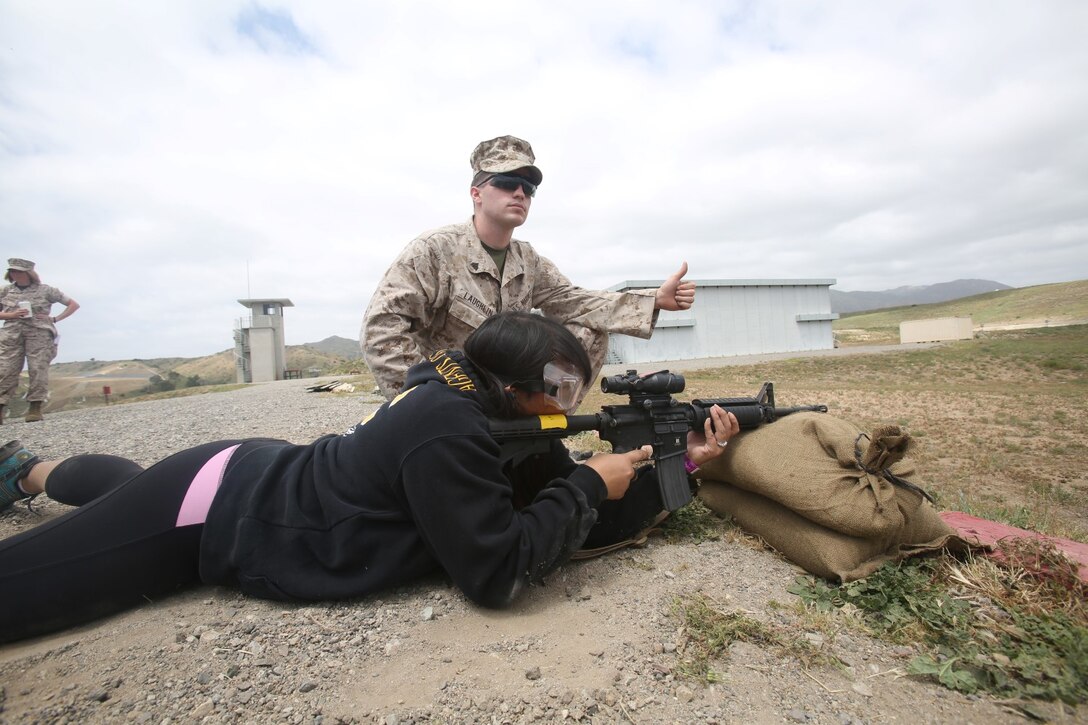 Participants of the Spartan Spouse Day held by the 9th Communication Battalion prepare to fire as range coaches give the all clear aboard Camp Pendleton, Calif., April 25. Marine spouses were invited to see what their significant others have gone through in training and their typical workdays.