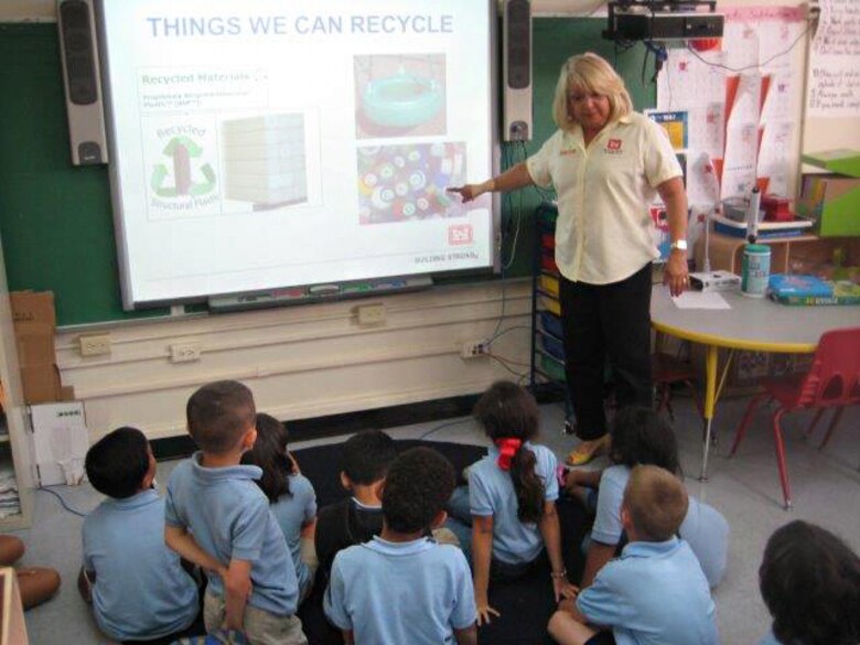 Carmen Martir, chief, administrative services in the Antilles Office, teaches first grade students at the Antilles Elementary School about the importance of recycling.