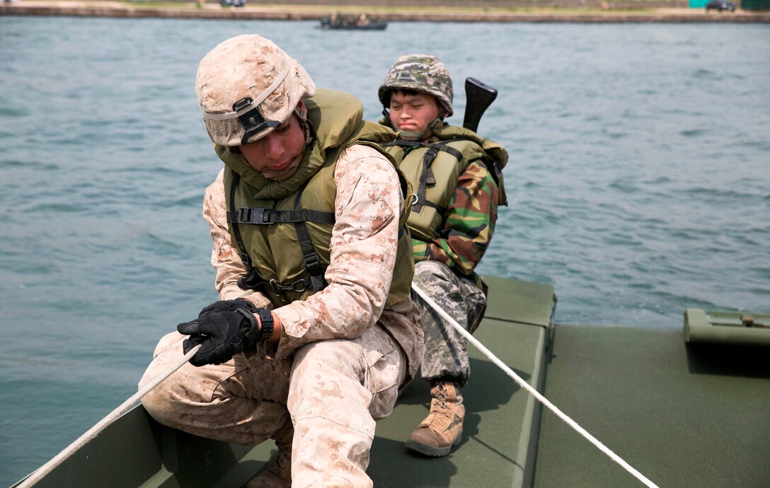 Republic of Korea Marine Lance Cpl. Park Ki Tae, right, and U.S. Marine Cpl. Anthony B. Lopez strain as they pull two parts of an improved ribbon bridge together April 22 during Korean Marine Exchange Program 14-6 on the Hysong River in Pohang, Republic of Korea. An IRB provides water-crossing capabilities either as a floating bridge or multibay raft for tactical vehicles. Tae is a combat engineer with the 1st ROK Marine Engineer Battalion, 1st ROK Marine Division. Lopez is a combat engineer with 9th Engineer Support Battalion, 3rd Marine Logistics Group, III Marine Expeditionary Force. (U.S. Marine Corps photo by Lance Cpl. Cedric R. Haller II/Released)
