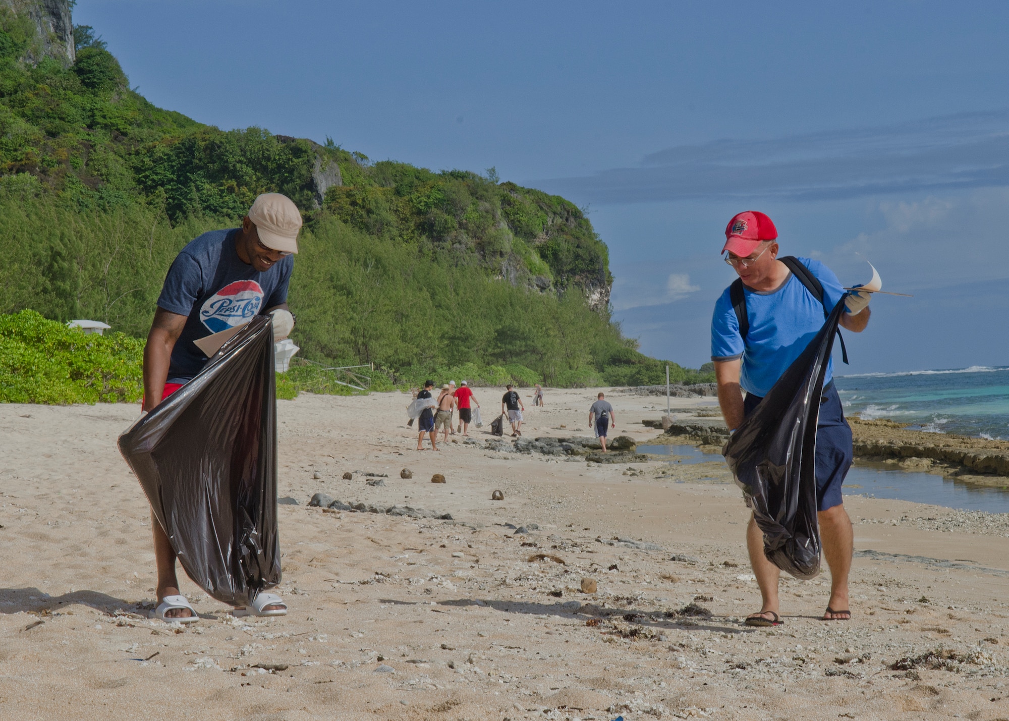 Master Sgt. Paul Johnson (left), 644th Combat Communications Squadron supply NCO in charge, and Tech. Sgt. Edward Mendiola, 254th RED HORSE HVAC technician, pick up trash along Tarague Beach during the 2nd Annual Earth Day Cleanup on Andersen Air Force Base, Guam, April 26, 2014. Approximately 35 volunteers picked up two truckloads of recyclable materials and refuse, ranging from cans to a tire. (U.S. Air Force photo by Senior Airman Katrina Brisbin/Released)
