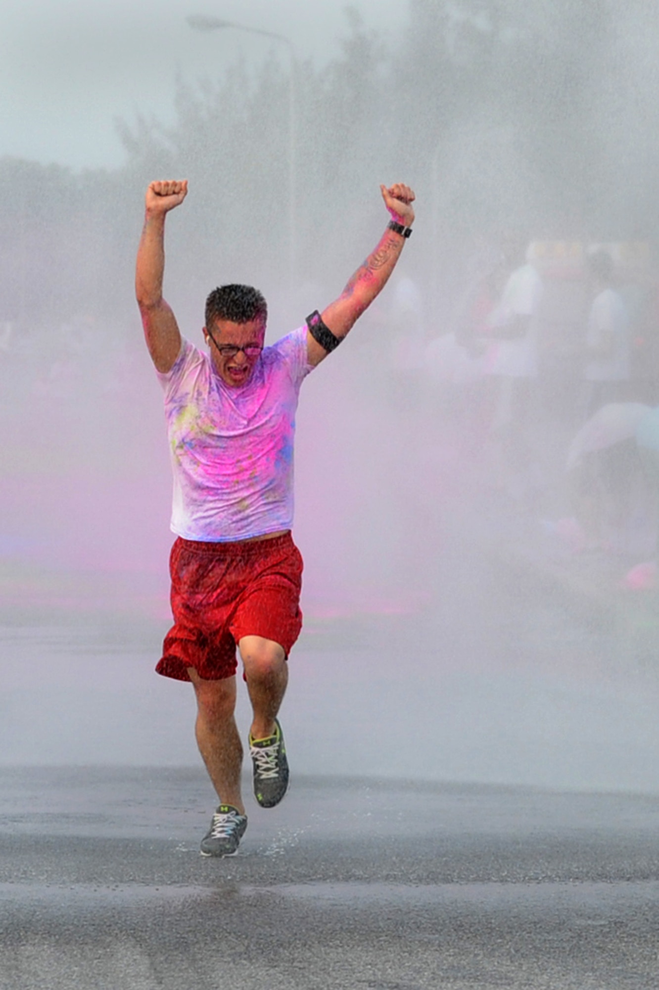 Airman 1st Class Steven Anderson, 18th Communications Squadron antenna systems technician, celebrates on the last leg of the Sexual Assault Prevention and Response color run on Kadena Air Base, Japan, April 30, 2014. This event was in support of not only Sexual Assault Awareness Month  but also Alcohol Awareness Month  and National Child Abuse Prevention Month.  (U.S. Air Force photo by Airman 1st Class Zackary A. Henry)
