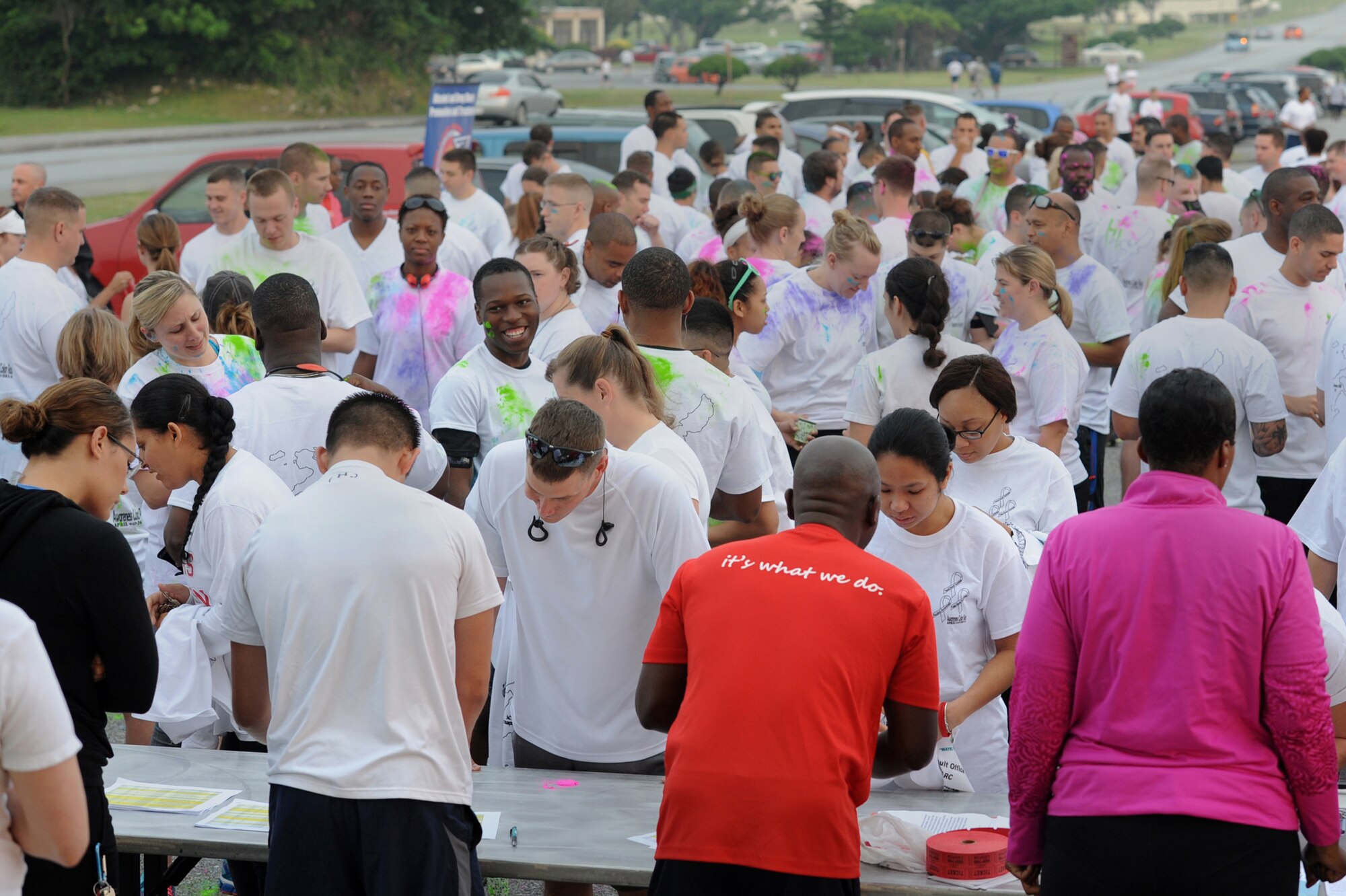 Volunteers assist participants registering  for the Sexual Assault Prevention and Response sponsored color run on  Kadena Air Base, Japan, April 30, 2014. Approximately 200 people signed up and ran during the color run to raise awareness and support the SAPR campaign. (U.S. Air Force photo by Airman 1st Class Zackary A. Henry)