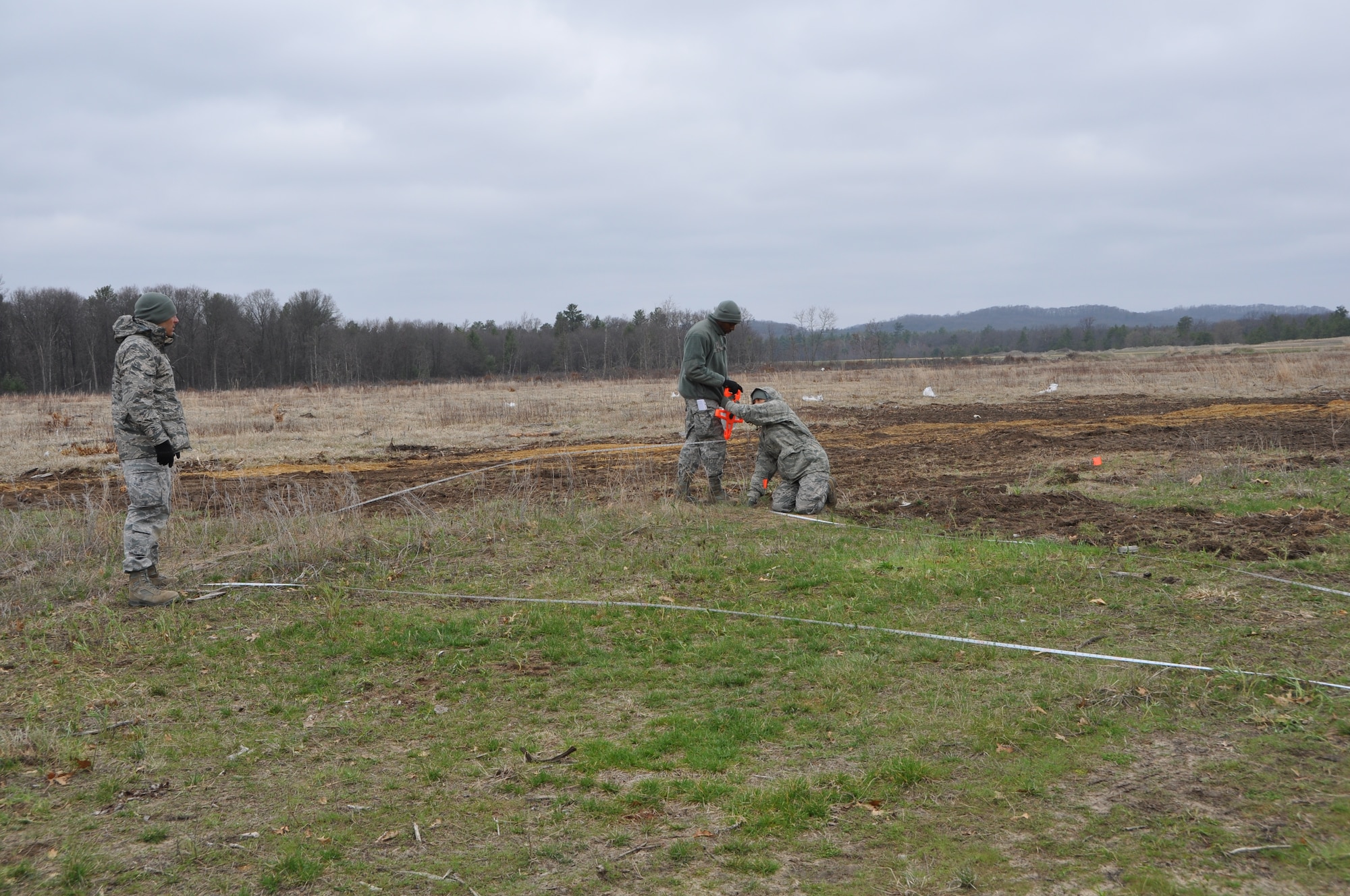 Tech. Sgt’s Kit Lui, left, and Jane Cummings, right and Senior Airman Lloyd Watkins, middle, of the 433rd Civil Engineer Squadron survey an area of Fort McCoy, Wis. April 26 where tents will be built from the ground up to form a Forward Operating Base in support of Exercise Patriot Warrior 2014. Air Force Reservists are a force multiplier to the Army in bare base bed down and sustainment for airlift support operations. The purpose of the exercise is moving injured personnel out of a war zone to a higher echelon of care.  (U.S. Air Force photo by 1st Lt. Denise Haeussler)