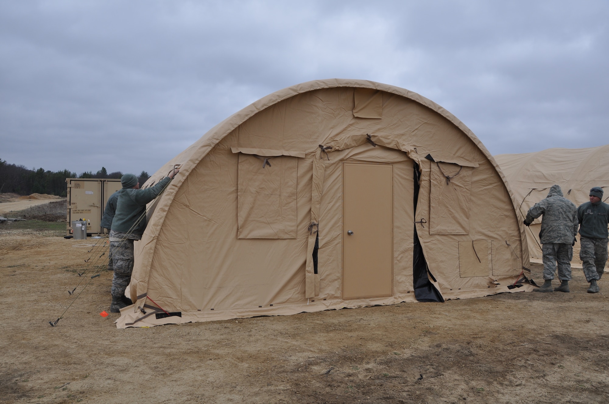 Reservists with the 433rd Civil Engineer Squadron put the final touches on a tent built from the ground up at Fort McCoy, Wis. April 26. CE is supporting Exercise Patriot Warrior by the bedding down and sustainment of a Forward Operating Base. Exercise Patriot Warrior is practice for a real world deployment where war fighters injured in a war zone are airlifted out to a higher echelon of care. (U.S. Air Force photo by 1st Lt. Denise Haeussler)