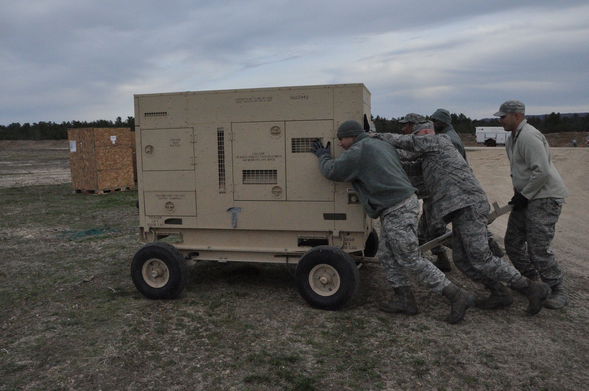 Reservists with the 433rd Civil Engineer Squadron push a generator into place at cold, wet, and muddy Fort McCoy, Wis., April 26 in support of Exercise Patriot Warrior 2014. The generators will be used to run power and heat into the working and living tents for the duration of the exercise. (U.S. Air Force photo by 1st Lt. Denise Haeussler)