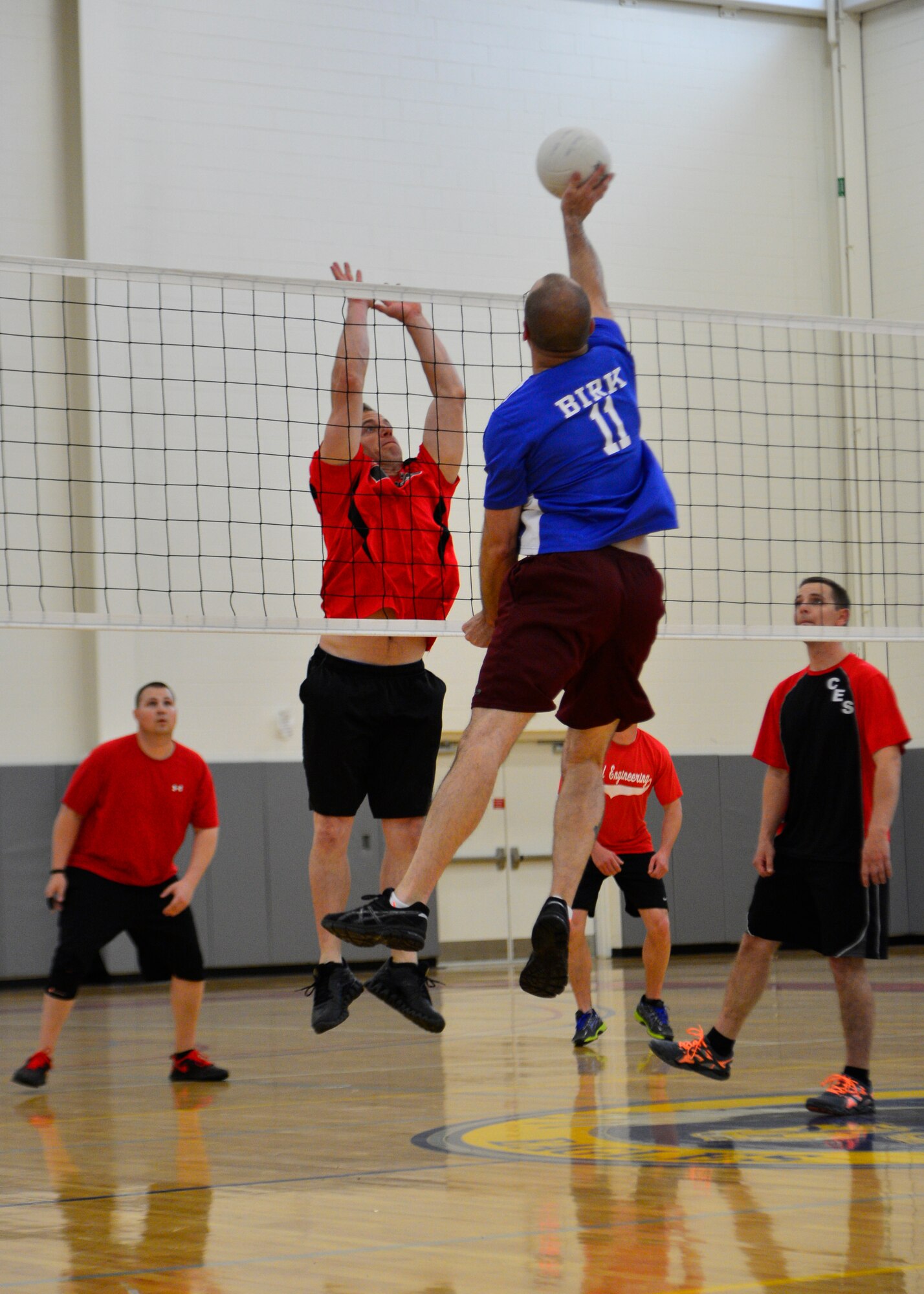 Wayne Birk, 436th Maintenance Squadron, goes for a kill as Steven Peaper, 436th Civil Engineer Squadron, attempts to block during an intramural volleyball game May 1, 2014, at the fitness center on Dover Air Force Base, Del. Birk had five kills in the 25-16 and 25-22 sweep against the 436th CES. (U.S. Air Force photo/Airman 1st Class William Johnson)