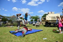 Aaralyn Baldwin, 7, pounces on her victim for the self-defense demonstration during Duke Field’s Family Day event May 3.  The 919th Special Operations Wing sets aside a special day each year to show appreciation for its reservists and their family members. Events included music, sports, children’s games, etc. (U.S. Air Force photo/Tech. Sgt. Jasmin Taylor)