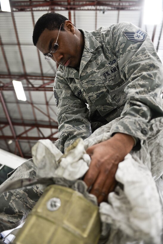 Staff Sgt. John Williams, 5th Operations Support Squadron aircrew flight equipment technician assigned to Minot Air Force, N.D., and on temporary duty at Ellsworth, packs a drag parachute for a B-52 Stratofortress at Ellsworth Air Force Base, S.D., April 30, 2014. Aircrew flight equipment members inspect and maintain life-saving instruments and gear for the B-52 as well as all 5th Bomb Wing aircrews. (U.S. Air Force photo by Senior Airman Zachary Hada/Released)
