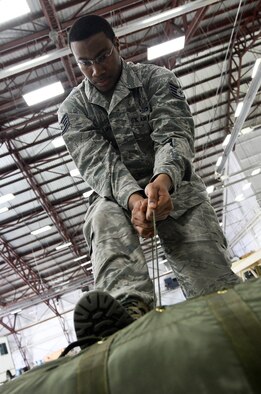 Staff Sgt. John Williams, 5th Operations Support Squadron aircrew flight equipment technician assigned to Minot Air Force Base, N.D. and on temporary duty at Ellsworth, packs a drag parachute for a B-52 Stratofortress at Ellsworth Air Force Base, S.D., April 30, 2014. Aircrew flight equipment members maintain more than $12 million worth of life support equipment on 5th Bomb Wing B-52s. (U.S. Air Force photo by Senior Airman Zachary Hada/Released)