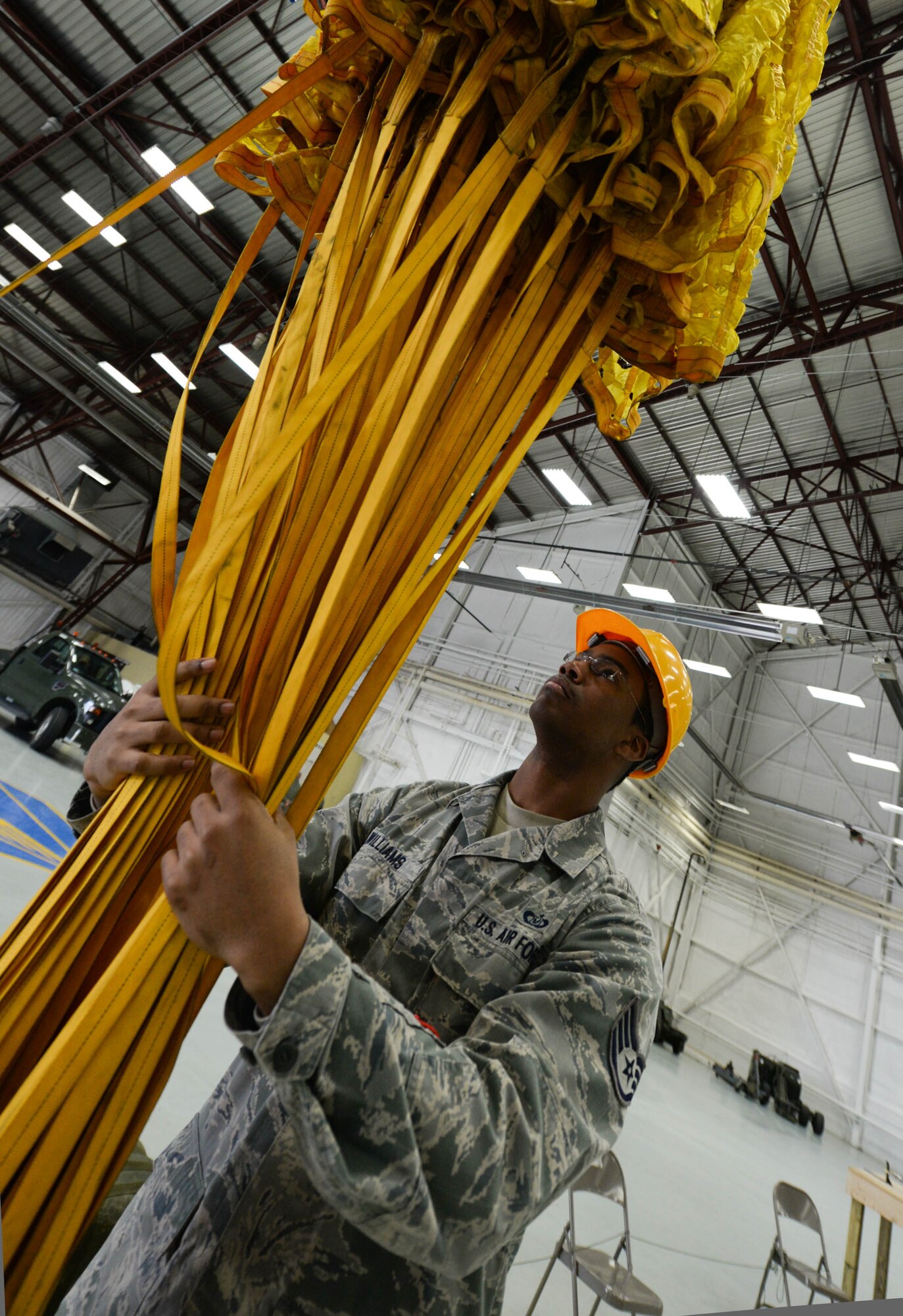 Staff Sgt. John Williams, 5th Operations Support Squadron aircrew flight equipment technician assigned to Minot Air Force Base, N.D., untangles parachute lines in a hangar retrofitted by 28th Civil Engineer Squadron Airmen at Ellsworth Air Force Base, S.D., April 30, 2014. More than 300 Airmen and approximately eight B-52 Stratofortresses are temporarily operating out of Ellsworth during a runway repair project at Minot. (U.S. Air Force photo by Senior Airman Zachary Hada/Released)