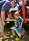 A young boy tries on the fire department’s protective gear during Duke Field’s Family Day event May 3.  The 919th Special Operations Wing sets aside a special day each year to show appreciation for its reservists and their family members. Events included music, sports, children’s games, etc. (U.S. Air Force photo/Tech. Sgt. Cheryl L. Foster)