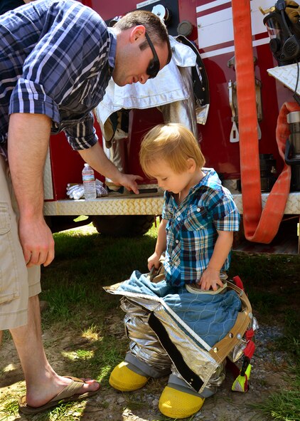 A young boy tries on the fire department’s protective gear during Duke Field’s Family Day event May 3.  The 919th Special Operations Wing sets aside a special day each year to show appreciation for its reservists and their family members. Events included music, sports, children’s games, etc. (U.S. Air Force photo/Tech. Sgt. Cheryl L. Foster)