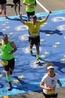 Senior Airman J.R. Fallon, a 58th Aerial Port Airman, crosses the finish line at the 118th Boston Marathon wearing his Air Force and Martin Richard Charitable Foundation gear. (Photo Courtesy of MarathonFoto)