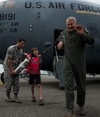 Col. Darren Hartford gets sprayed by his son Matthew with the assistance of Staff Sgt. David Glowacki, 437th Operations Support Squadron weather forecaster, after finishing his final flight as the 437th Airlift Wing commander May 2, 2014, on the flightline at Joint Base Charleston, S.C. The final or "fini flight," is an aviation tradition in which aircrew members are met by their unit comrades, family and friends and soaked with water. (U.S. Air Force photo/ Airman 1st Class Clayton Cupit)