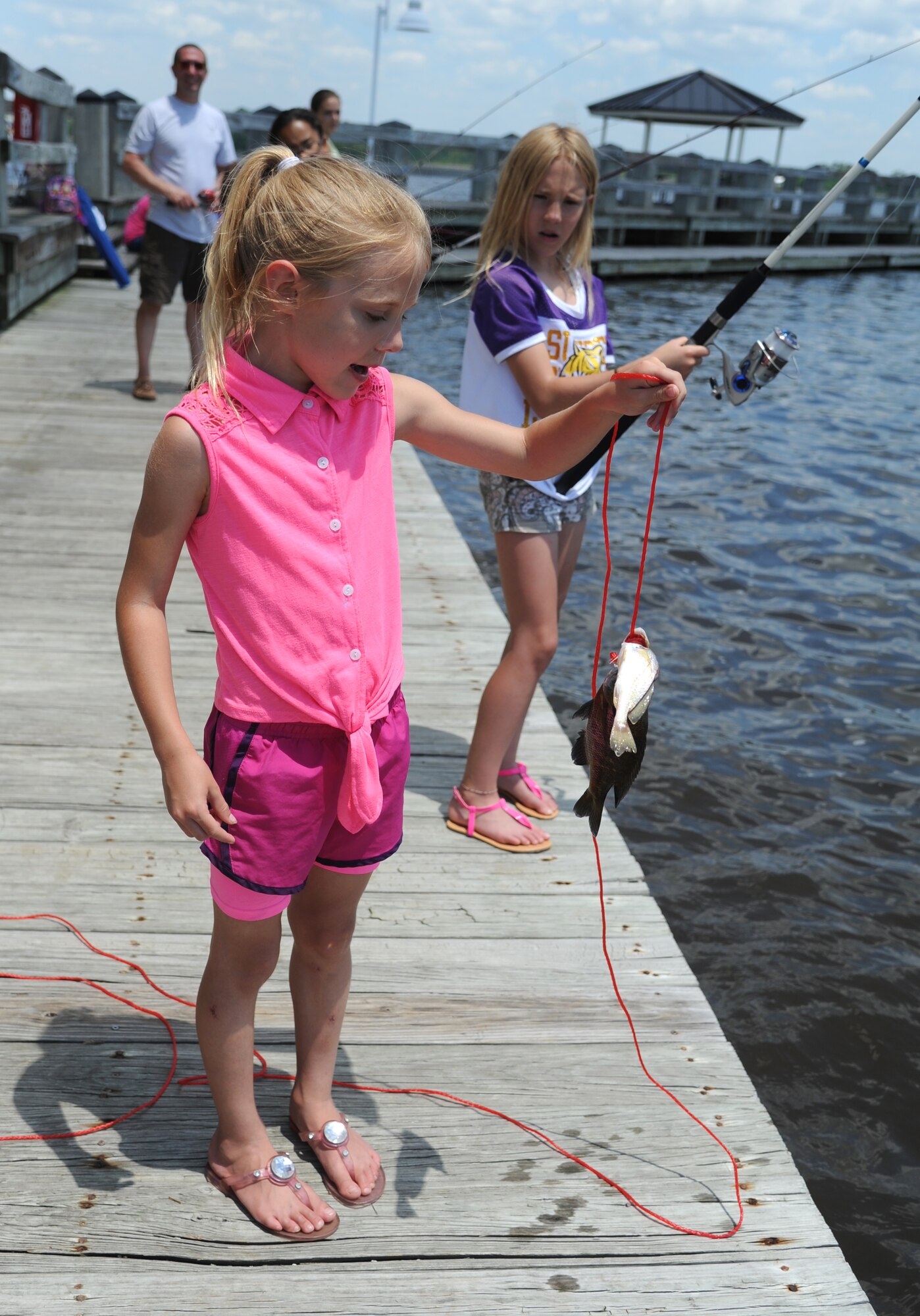 The daughter of Troy Kirkbride, 334th Training Squadron, proudly displays a couple of fish she caught during the Kids Spring Fishing Rodeo May 3, 2014, at the marina, Keesler Air Force Base, Miss.  The event was hosted by the outdoor recreation center. (U.S. Air Force photo by Kemberly Groue)