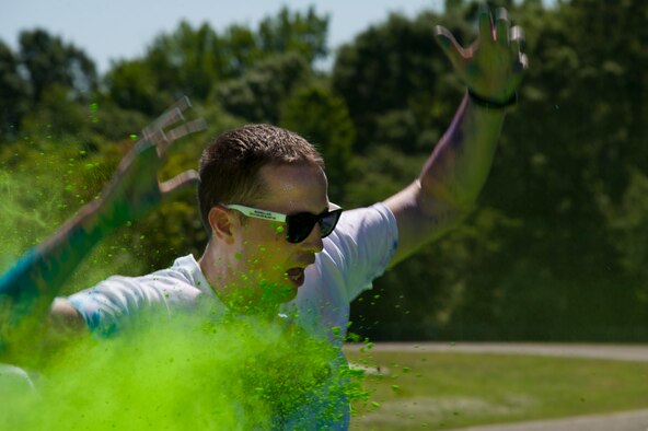 A color run participant runs through a cloud of green dust at the Maxwell Air Force Base color run May 3, 2014. Adults, children and even dogs ran the 5K course, and enjoyed festivities at the finish. (U.S. Air Force photo by Staff Sgt. Natasha Stannard)