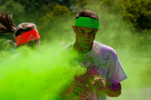 Runners brace themselves as they enter a cloud of green dust at the Maxwell Air Force Base color run May 3, 2014. The event was hosted by the 42nd Force Support Squadron fitness center and outdoor recreation center. They also hosted a color party with a DJ after the run. (U.S. Air Force photo by Staff Sgt. Natasha Stannard)